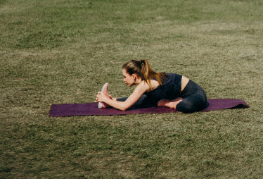 Frau macht Yoga im Garten