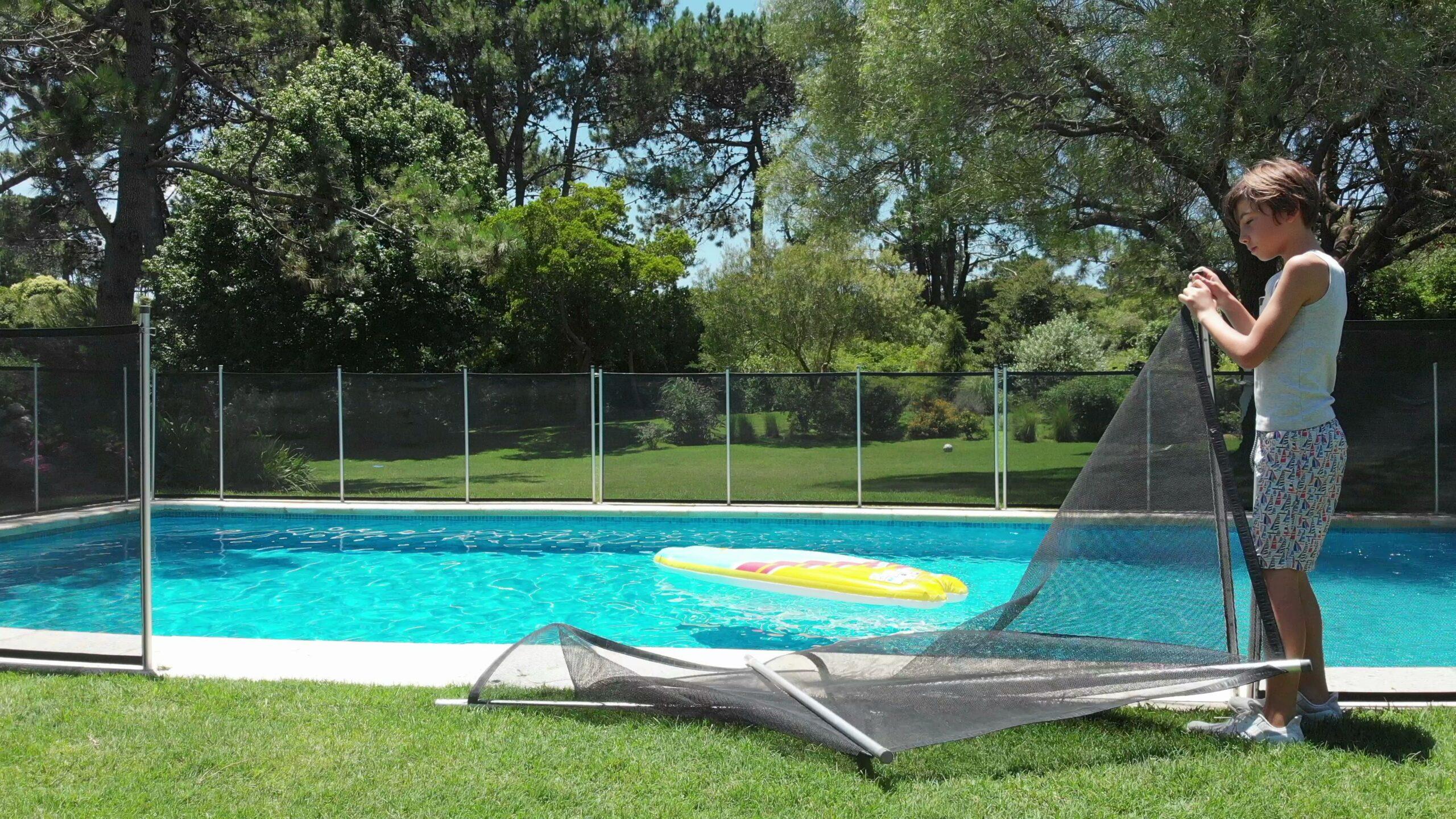 Ein Kind befestigt gerade einen Sicherheitszaun um einene Pool